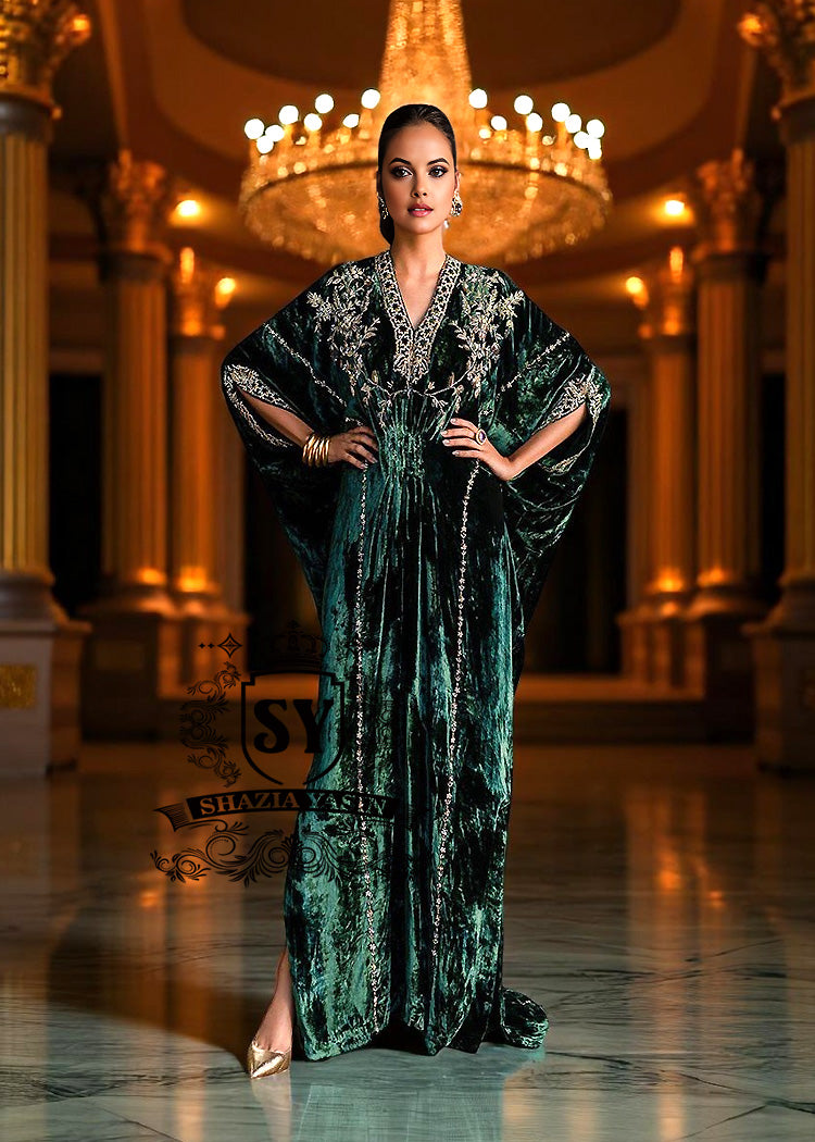 Woman in a green evening Kaftan standing in an opulent room with a chandelier