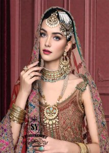 Immerse yourself in the timeless brilliance of a Pakistani couture bridal lehenga. Vibrant traditional hues of red are lightly interwoven with shimmering gold, enveloping the bride in an aura of glamour and grace.