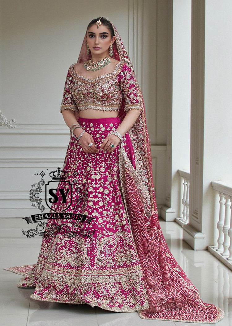 BridalDress195A The Dogwood Rose bridal look evokes an aura of ancient majesty. A richly hand-embellished lehenga choli, structured yet flowing, sparkles with dabka details, stones, sequins, beads, silk threads, and Swarovski crystals. Paired with layered raw jewels and a striking jewel-pink dupatta, it captures the grandeur of old-world bridal elegance through a contemporary lens.