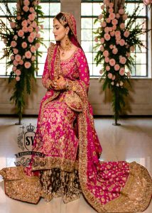 A timeless bridal dress design that exudes classic elegance and meticulous craftsmanship. The intricately crafted, opulent Banarsi Jamawar lehenga exudes a royal flair, with its heavy maroon and red borders creating a magnificent, flowing train.