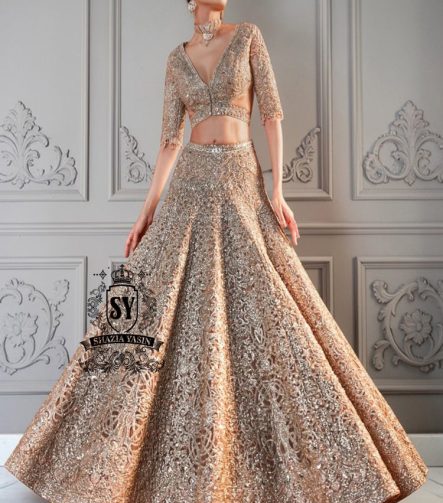 The essence of romance reimagined into a showstopping Lehenga silhouette. This bridal dress features a sculpted choli bodice with a dramatic front waist and daring sheer side cutouts, creating an interplay of strength and sensuality.