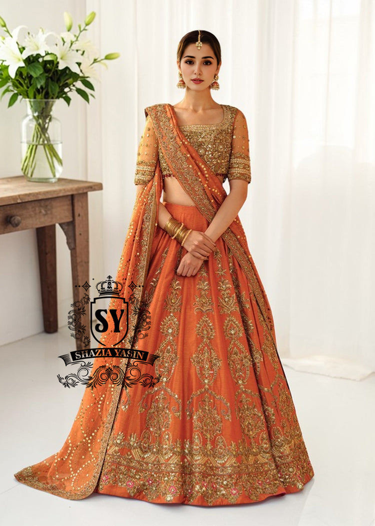 BridalDress211A A stunning ensemble featuring Persimmon net blouse and an intricately embroidered Raw silk lehenga in the same vibrant hue. A shimmering kaamdani dupatta adds charm and sophistication to the ensemble.