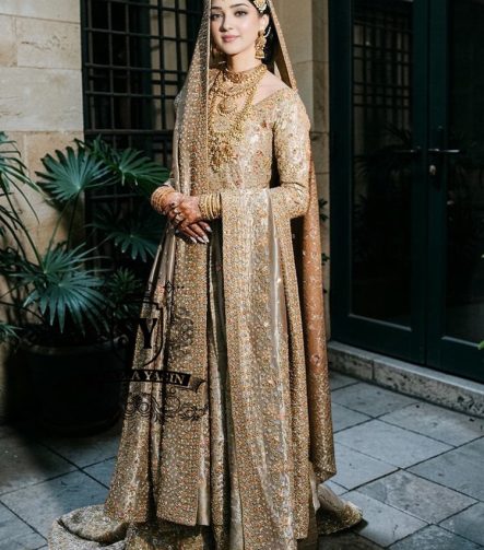 A majestic wedding dress made of luxurious Lame fabric in a lush farshi lehenga silhouette that radiates elegance. Long shirt creates an exquisite effect. The decor in the form of delicate flourishing embellishments adds romance.