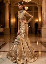 Ivy is a mermaid wedding dress that fascinates with the refinement of its lehenga silhouette, which delicately follows the lines of the body and highlights a timeless elegance. The blouse of the dress is outlined by a embellished neckline, while the long sleeves, made entirely of net with shiny floral embellishments, add an extra touch of sophistication.