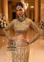 Ivy is a mermaid wedding dress that fascinates with the refinement of its lehenga silhouette, which delicately follows the lines of the body and highlights a timeless elegance. The blouse of the dress is outlined by a embellished neckline, while the long sleeves, made entirely of net with shiny floral embellishments, add an extra touch of sophistication.