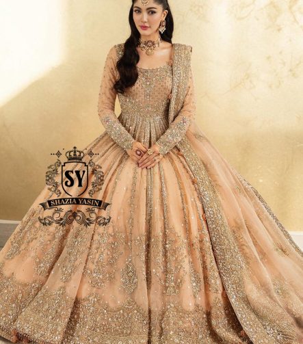 In a radiant shade of Peach puff, this bridal dress captures a timeless grandeur, sweetened with touches of pastel romance. This open-cut kalidaar gown shines with tissue silk lehenga.