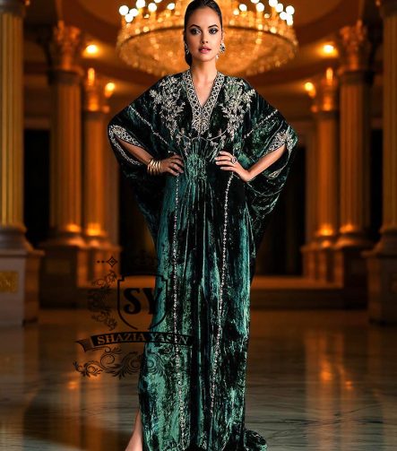 Woman in a green evening Kaftan standing in an opulent room with a chandelier