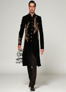 The Rich Black Sherwani jacket with a mandarin collar and jeweled shimmering gold zari embellishments on the front evokes regal elegance, reinterpreted with a modern twist.