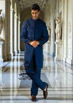 This Admiral Blue sherwani redefines elegance with its intricately executed tone-on-tone adah work, exuding a royal aura with a distinctive modern edge, embodying royal sophistication yet suited to the modern man.
