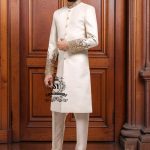 An off-white sherwani design imbued with artistic spirit, every detail meticulously crafted to celebrate the elegant beauty of the groom. The combined with delicate buttons running down the center, creating a focal point that is both classic and modern.