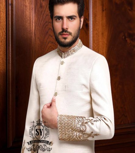 An off-white sherwani design imbued with artistic spirit, every detail meticulously crafted to celebrate the elegant beauty of the groom. The combined with delicate buttons running down the center, creating a focal point that is both classic and modern.