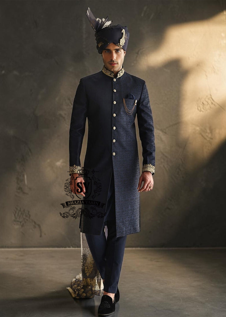 Sherwani211a Indulge in a blissful moment with the beautiful Jets Navy Embellished Sherwani For Wedding, crafted from high-quality Jamawaar fabric. Perfect for any wedding occasion, this sherwani will make you shine on your special day.