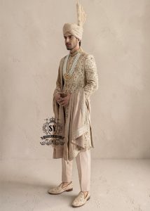 This sherwani is a masterpiece that blends timeless nobility with a modern sensibility. A finely hand-embroidered sherwani by Shazia Yasin, elevated with gold accents, paired with a statement mala, shawl and a bold turban for a timeless yet striking look.