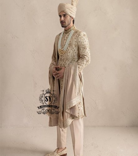 This sherwani is a masterpiece that blends timeless nobility with a modern sensibility. A finely hand-embroidered sherwani by Shazia Yasin, elevated with gold accents, paired with a statement mala, shawl and a bold turban for a timeless yet striking look.