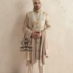 This sherwani is a masterpiece that blends timeless nobility with a modern sensibility. A finely hand-embroidered sherwani by Shazia Yasin, elevated with gold accents, paired with a statement mala, shawl and a bold turban for a timeless yet striking look.