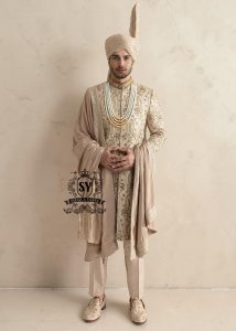 This sherwani is a masterpiece that blends timeless nobility with a modern sensibility. A finely hand-embroidered sherwani by Shazia Yasin, elevated with gold accents, paired with a statement mala, shawl and a bold turban for a timeless yet striking look.